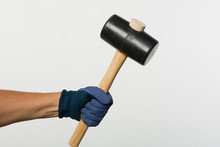 Hand In Work Glove Holds A Rubber Hammer