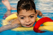 © Jordi Mora - niño jugando y riendo en terapia en piscina con tubo flotador