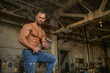 © xpabli - Muscled half naked man at work in an old factory.