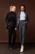 Two sexy beautiful woman fashion glamour model brunette blond hair makeup wear suit trousers jacket clothes every day casual office dress code party style accessory date walk skinny body shape studio.