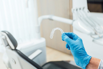 Doctor hand holding a clear dental aligner