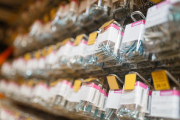 Canvas Print - Rows of boxes with bolts in hardware store closeup