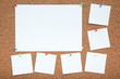 a sheets of paper are attached to the cork Board with a push-buttons. empty note papers pinned on corkboard