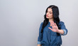 Young woman making a rejection pose on a gray background