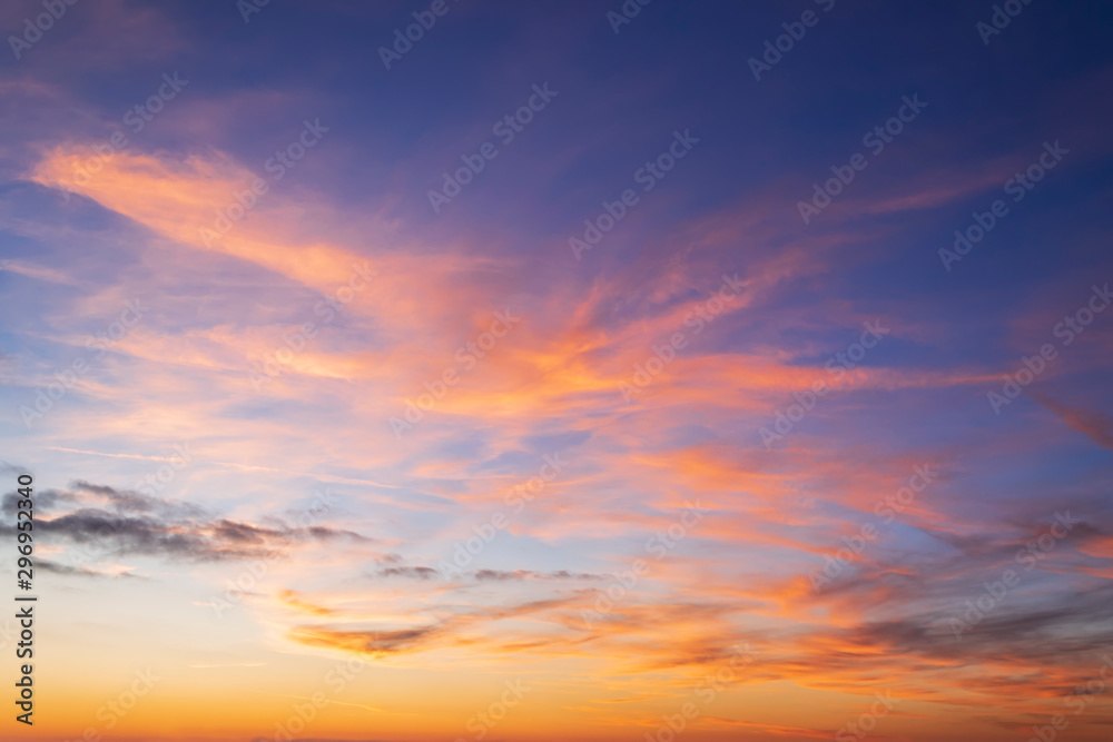 Beautiful orange clouds on a golden blue sky during sunset. Scenic sundown cloudscape for background. Afterglow of sunset. - obrazy, fototapety, plakaty 