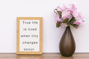 Wall Mural - True life is lived when tiny changes occur - Inspiration quotes on wooden frame.
