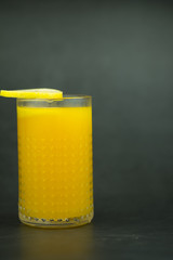 Wall Mural - Orange juice in the glass on dark background