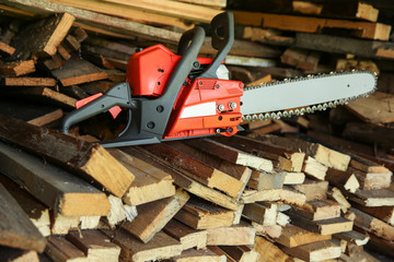 Wall Mural - chainsaw is against the background of firewood