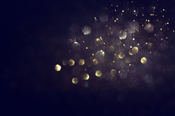 background of abstract glitter lights. gold and black. de focused