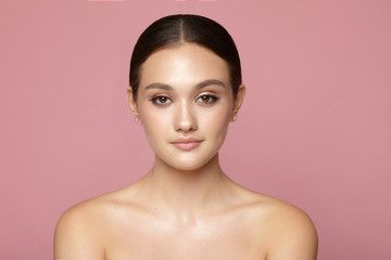 young girl clean skin  with natural makeup on a pink background 