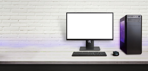 Fototapete - Modern gaming computer on desk. Isolated screen for mockup. Copy space beside on brick wall.