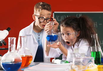 Children doing chemical research in laboratory. Dangerous experiment