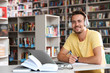 © New Africa - Young man studying at table in modern library