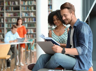 Wall Mural - Young people studying together in modern library