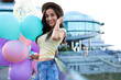 © New Africa - Beautiful young woman with color balloons on city street