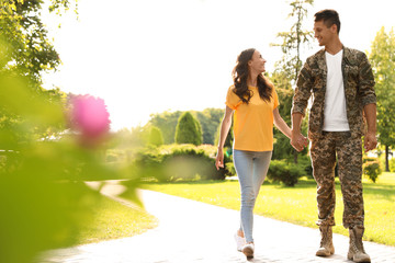 Wall Mural - Man in military uniform walking with his girlfriend at sunny park