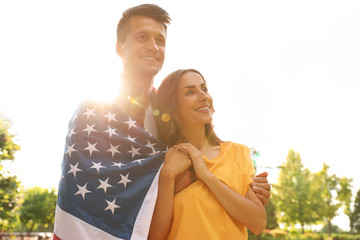 Wall Mural - Man in military uniform with American flag and his wife at sunny park