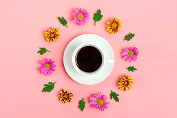 white cup with Americano coffee and round floral frame of chrysanthemum flowers on pink background Flat lay Top view holiday card	