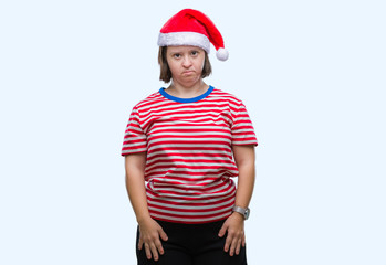 Canvas Print - Young adult woman with down syndrome wearing christmas hat over isolated background with serious expression on face. Simple and natural looking at the camera.