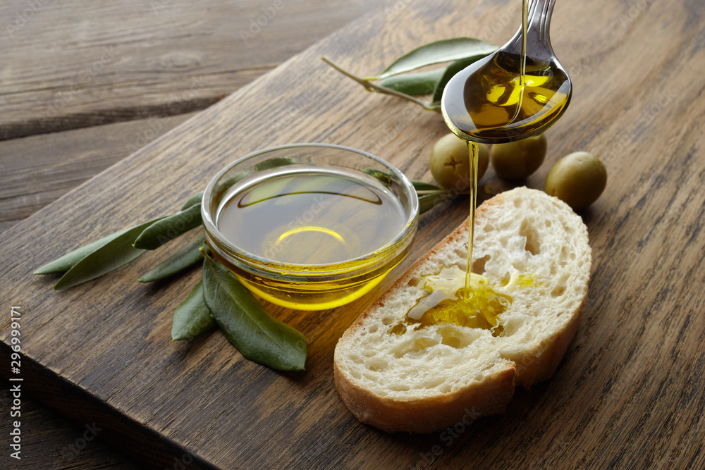 slice of bread seasoned with olive oil on wooden background - obrazy, fototapety, plakaty 
