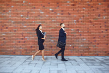 Businesspeople Walking On Brick Wall Background. Concept Of Business Job Professional Meeting.