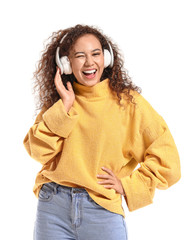 Poster - Beautiful African-American woman listening to music on white background