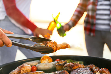 Wall Mural - Friends cooking tasty food on barbecue grill outdoors, closeup