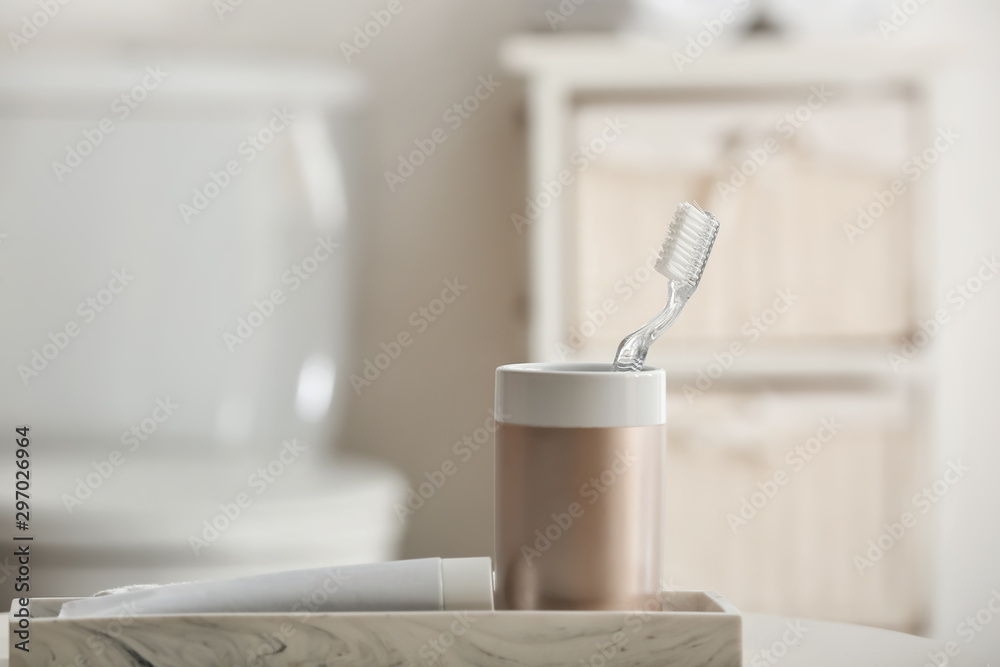 Toothbrush with paste on table in bathroom