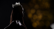Portrait Of Miss Pageant Beauty Contest In Sequin Evening Ball Gown Long Dress With Sparkle Light Diamond Crown, Silhouette Low Key Exposure With Curtain, Studio Lighting Dark Background Dramatic