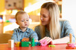 © Oksana Kuzmina - Mother and child son are talking and smiling while playing with educational toys at home