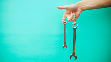 wrench in hands, on a blue background