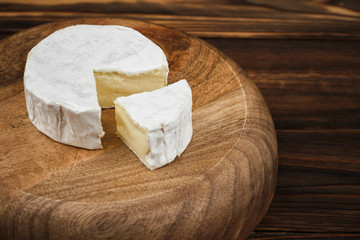 closeup view of camembert cheese on wooden plate. wood background