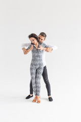 Wall Mural - Young couple dancing latin dance bachata, merengue, salsa, kizomba. Two elegance pose over white background with copy space