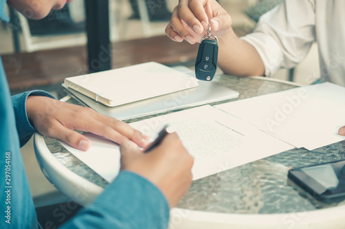 Fotomural dealer salesman giving car key to owner