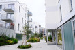 Sidewalk in a cozy courtyard of modern apartment buildings condo with white walls.