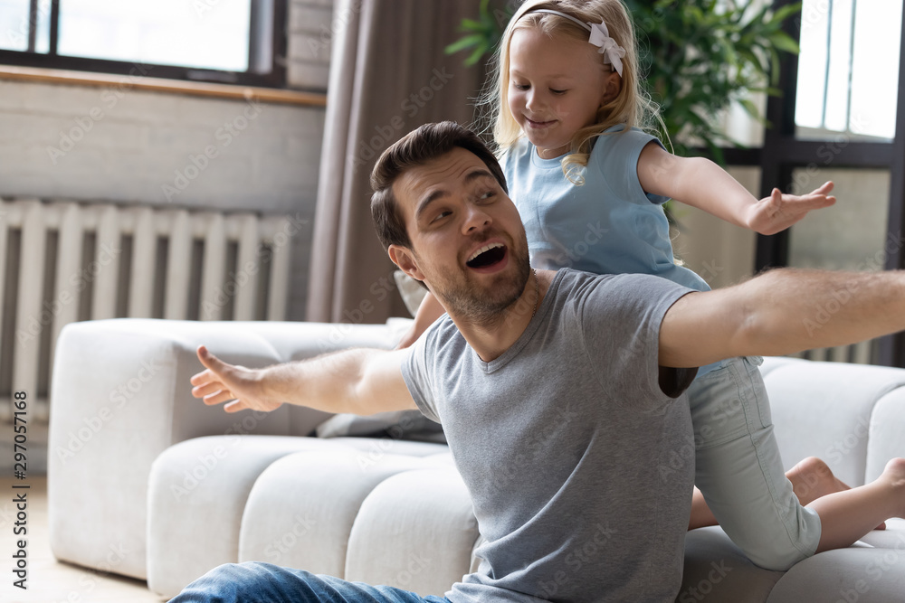 Happy father playing with little daughter in living room - obrazy, fototapety, plakaty 