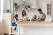 © fizkes - Happy family with little children preparing salad together