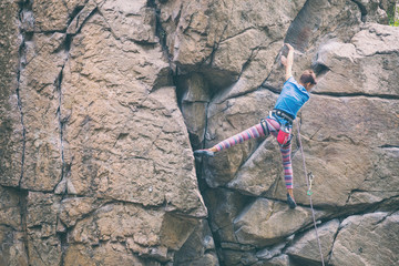 Poster - The girl climbs the granite rock.