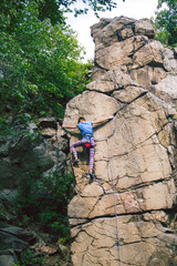 Sticker - The girl climbs the granite rock.