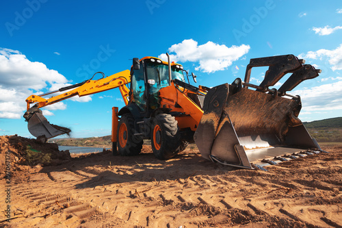 Fotografía Wheel loader excavator with field background during earthmoving work, constructi