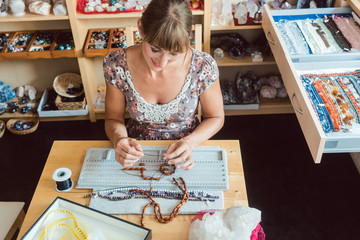 Woman working on a gemstone necklace as a hobby