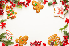 Christmas Background With Gingerbread Cookies And Branches Of Holly With Red Berries On White. Winter Festive Nature Concept. Flat Lay, Copy Space.