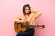 © luismolinero - Young brunette girl with guitar over isolated pink background having doubts and with confuse face expression