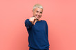 © luismolinero - Teenager girl with white short hair over pink wall points finger at you with a confident expression