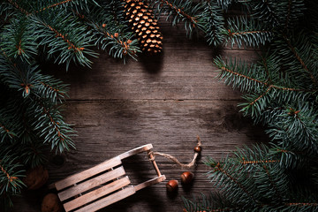 Wall Mural - Christmas frame from fir branches on a background of an old gray board around an open notebook with blank sheets. Frame of fir branches. Christmas card blank concept.