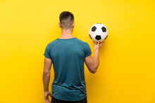 Handsome Young Football Player Man Over Isolated Yellow Background In Back Position