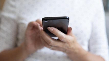 Canvas Print - Senior woman holding smartphone using mobile app, close up view