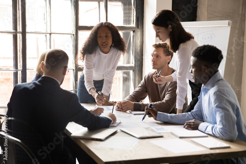 Fotomural Serious diverse business team and african leader discuss financial paperwork