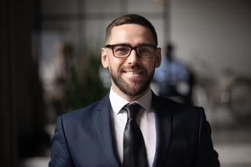 Wall Mural - Smiling businessman executive looking at camera in office, business portrait