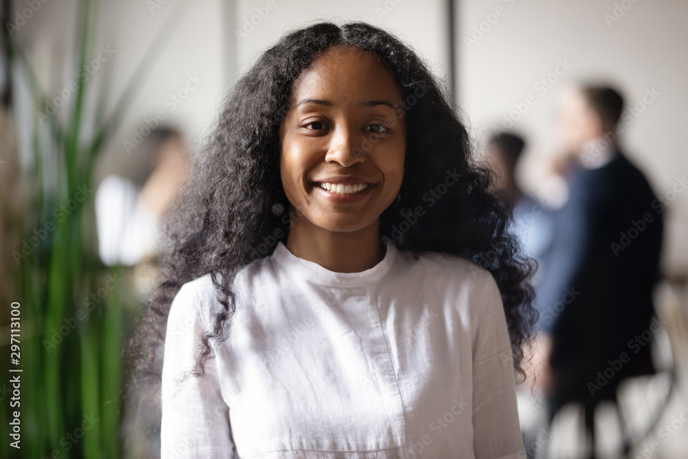 Smiling young african businesswoman looking at camera in office ...